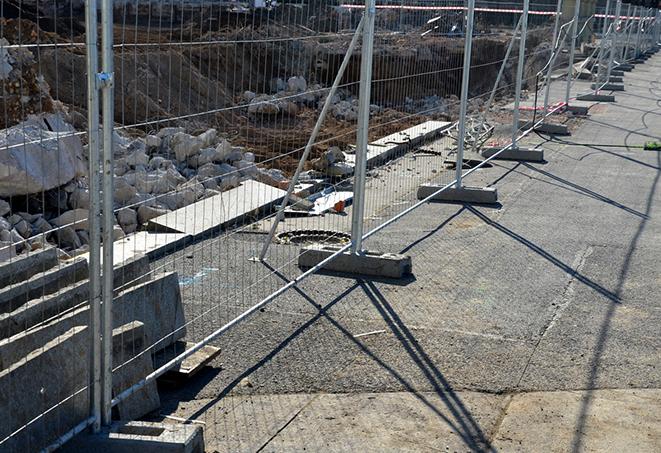 a temporary fence being used as a safety barrier at a demolition site